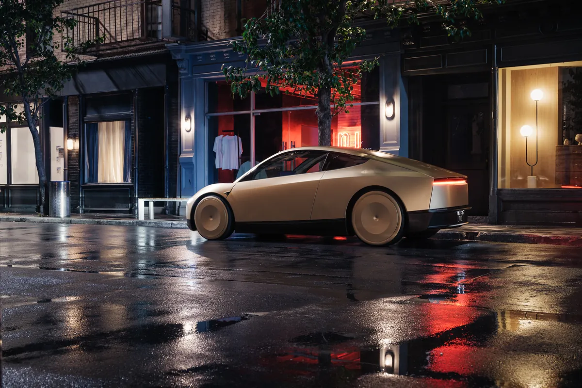 Tesla Cybercab de trois quarts arrière sur une chaussée mouillée reflétant les vitrines.