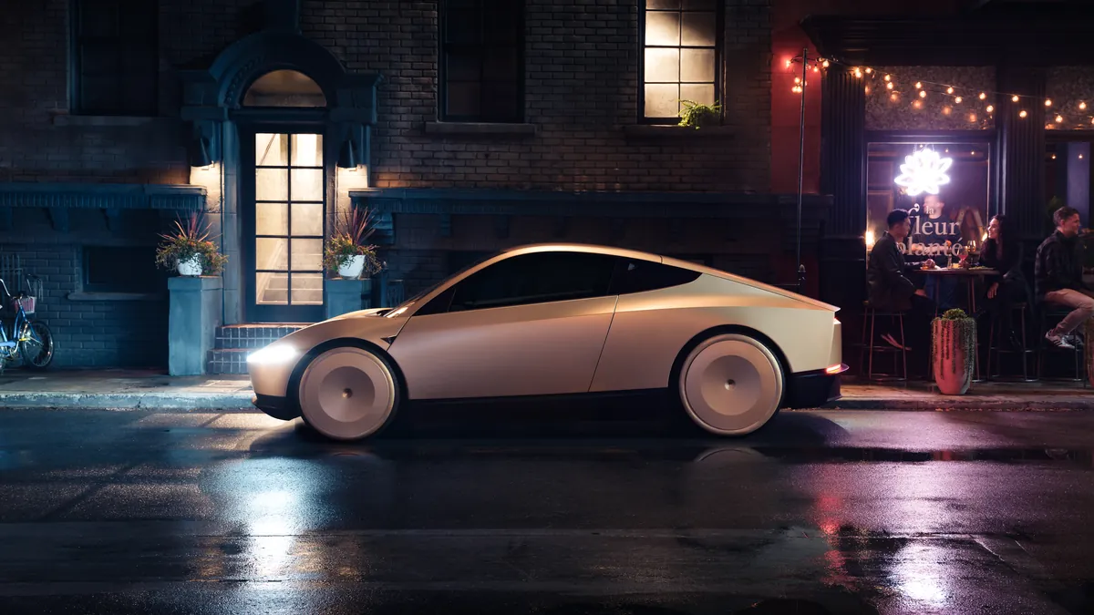 Tesla Cybercab à l’arrêt de nuit devant un établissement éclairé, sans passager visible à bord.
